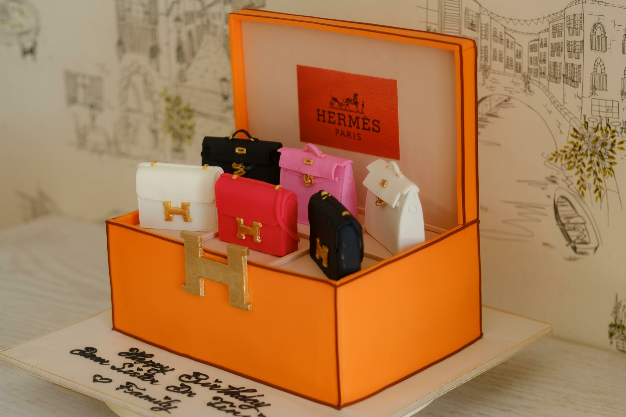 A Hermes-themed cake featuring miniature handbag decorations in vibrant colors, perfect for luxury fashion enthusiasts.